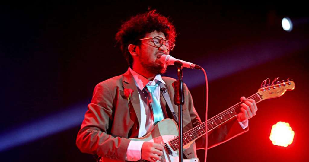 Kunto Aji membawakan gitar listrik sambil menyanyi di atas panggung